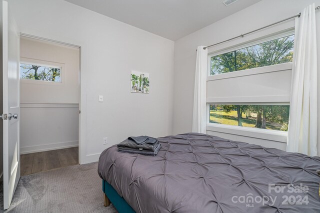 bedroom with multiple windows and hardwood / wood-style flooring