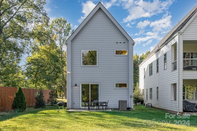 back of property featuring cooling unit, a lawn, and a patio