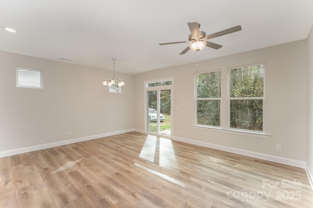 unfurnished room featuring light wood-style floors, recessed lighting, baseboards, and ceiling fan with notable chandelier