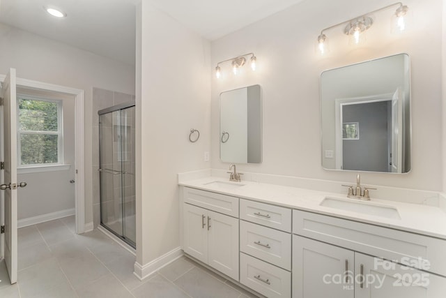 full bath featuring a sink, a shower stall, and double vanity