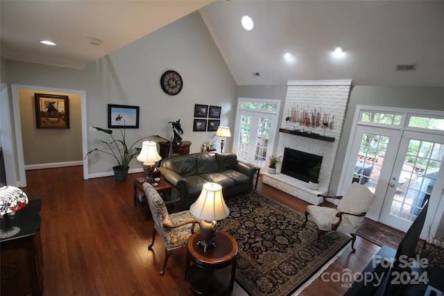 living room featuring french doors, high vaulted ceiling, a brick fireplace, and dark wood-type flooring