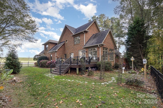 rear view of property with a wooden deck and a yard