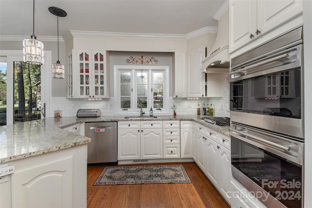 kitchen with decorative backsplash, appliances with stainless steel finishes, dark hardwood / wood-style flooring, and white cabinetry