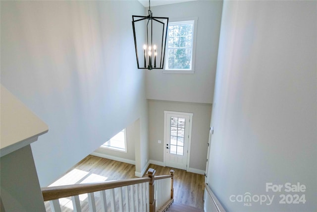 entryway with a healthy amount of sunlight, light hardwood / wood-style flooring, a high ceiling, and an inviting chandelier