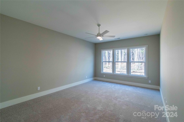 carpeted spare room featuring ceiling fan