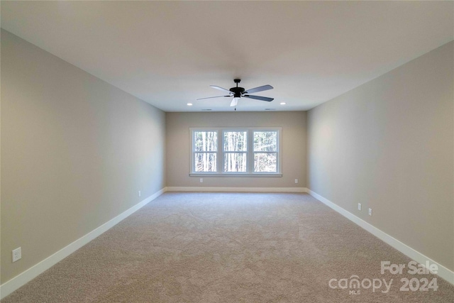 carpeted spare room featuring ceiling fan