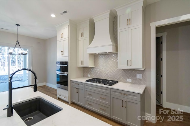 1865 Rock Hill Church Rd Unit 3, Matthews, NC 28104 - kitchen with custom exhaust hood, stainless steel appliances, gray cabinetry, tasteful backsplash, and pendant lighting