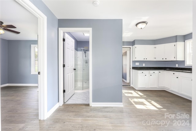 kitchen featuring white cabinets, ceiling fan, and light wood-type flooring