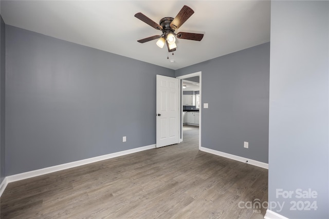 empty room with hardwood / wood-style flooring and ceiling fan