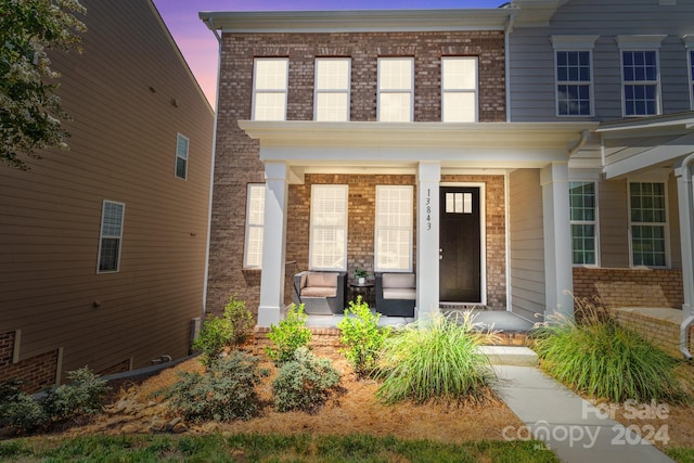 exterior entry at dusk with covered porch