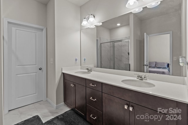 bathroom featuring a shower with shower door and vanity