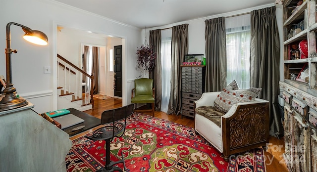 living area featuring hardwood / wood-style flooring and crown molding