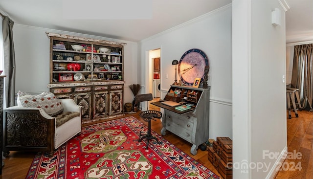 sitting room featuring ornamental molding, hardwood / wood-style floors, and washer / dryer