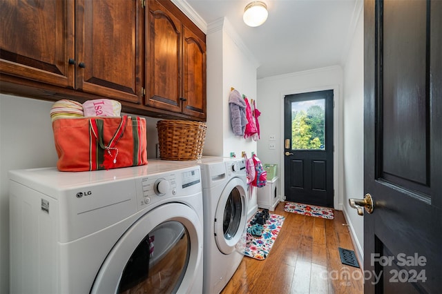 clothes washing area with washer and clothes dryer, wood-type flooring, cabinets, and crown molding