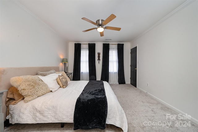 carpeted bedroom with ornamental molding and ceiling fan