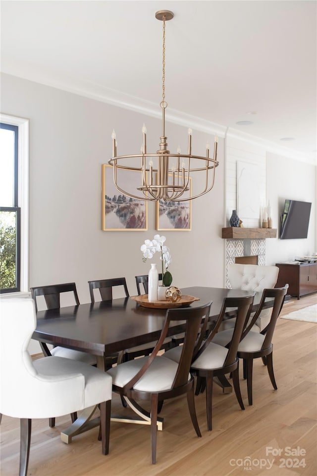 dining area featuring crown molding, light hardwood / wood-style flooring, and a chandelier