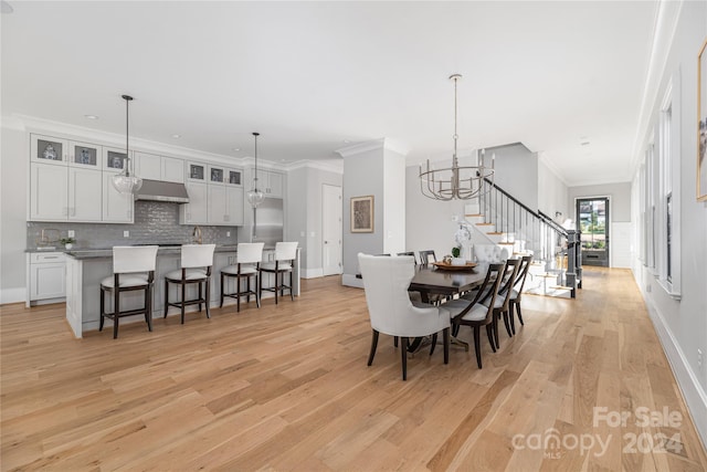 dining room with a chandelier, light hardwood / wood-style flooring, and crown molding