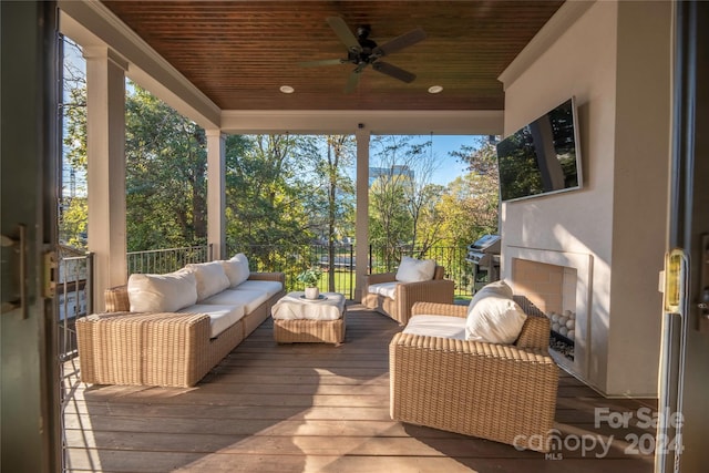 wooden terrace with outdoor lounge area and ceiling fan