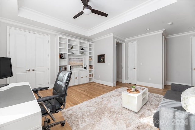 office area featuring a tray ceiling, ceiling fan, light hardwood / wood-style floors, and ornamental molding