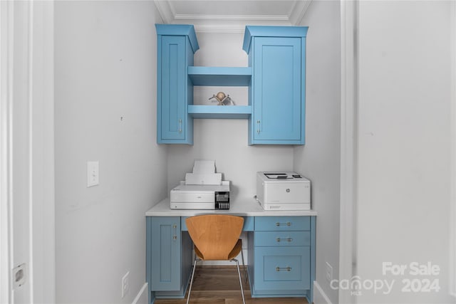 office space featuring dark hardwood / wood-style flooring, built in desk, and crown molding