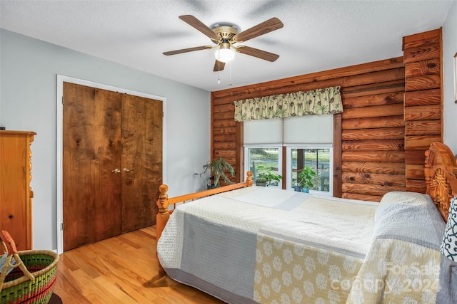 bedroom with a textured ceiling, ceiling fan, light hardwood / wood-style flooring, and a closet