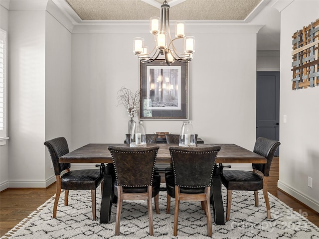 dining area featuring ornamental molding, a textured ceiling, hardwood / wood-style flooring, and a chandelier