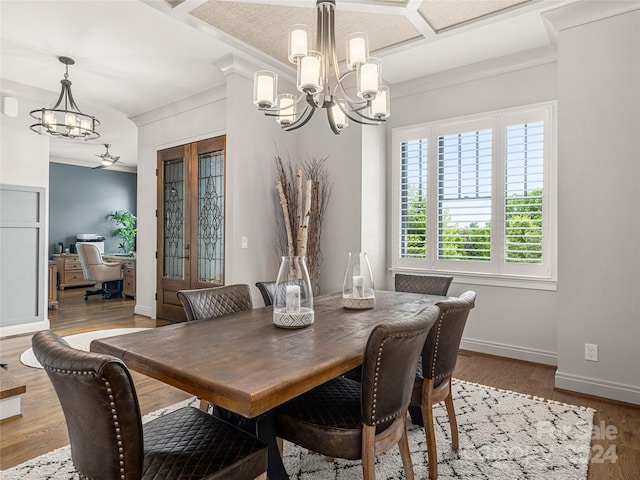 dining room featuring wood-type flooring, ceiling fan with notable chandelier, and crown molding