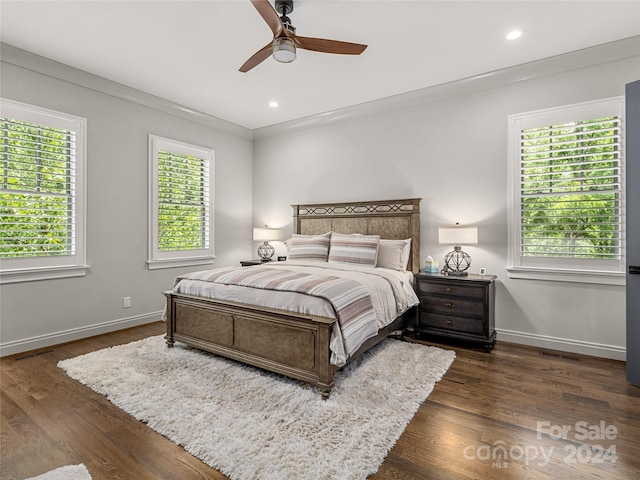 bedroom featuring ornamental molding, multiple windows, dark hardwood / wood-style flooring, and ceiling fan