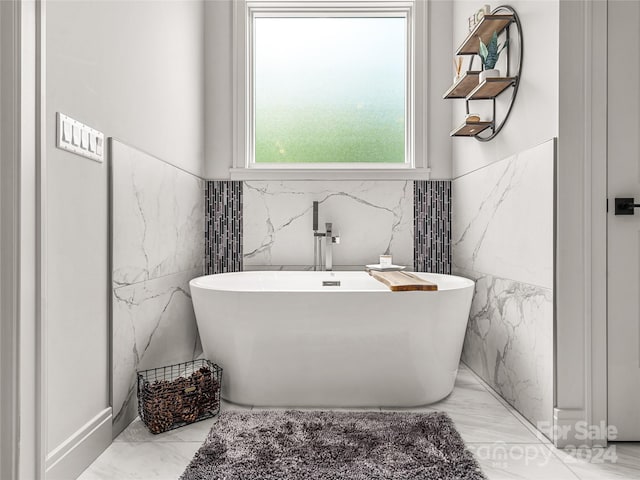 bathroom with a bathing tub and tile walls