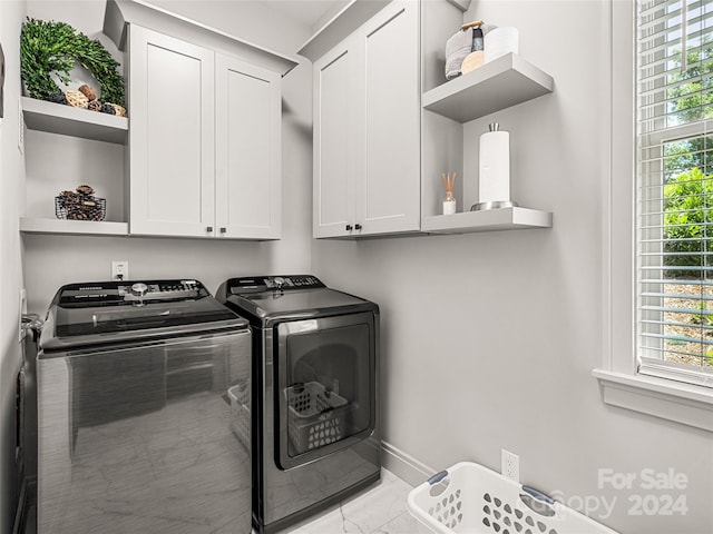 laundry area with cabinets, a healthy amount of sunlight, and independent washer and dryer