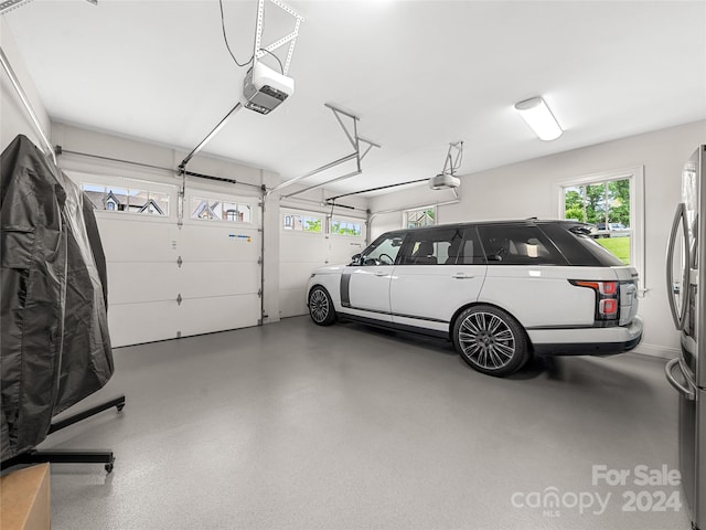 garage with a garage door opener and stainless steel fridge