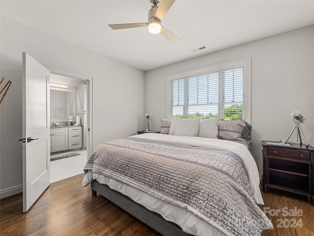 bedroom with dark wood-type flooring, ceiling fan, and connected bathroom