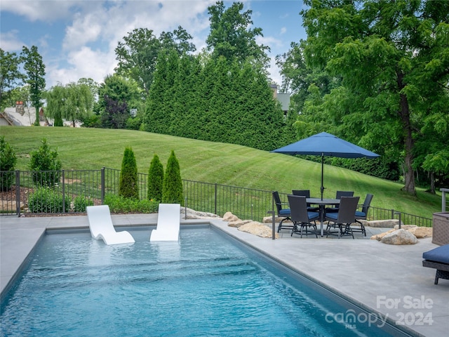 view of pool featuring a patio and a lawn