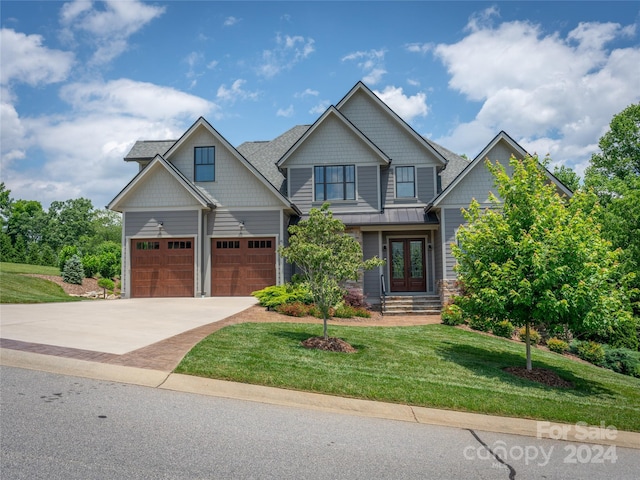 craftsman-style home featuring a garage and a front lawn