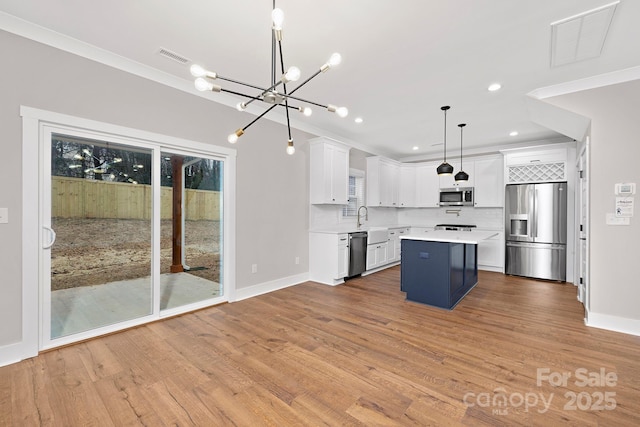 kitchen with white cabinetry, stainless steel appliances, tasteful backsplash, pendant lighting, and a kitchen island