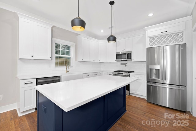 kitchen with white cabinetry, a center island, hanging light fixtures, stainless steel appliances, and dark hardwood / wood-style floors