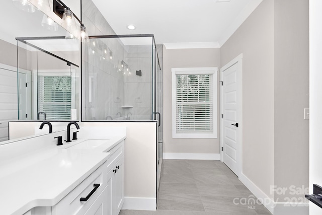 bathroom with tile patterned floors, crown molding, vanity, and a shower with shower door