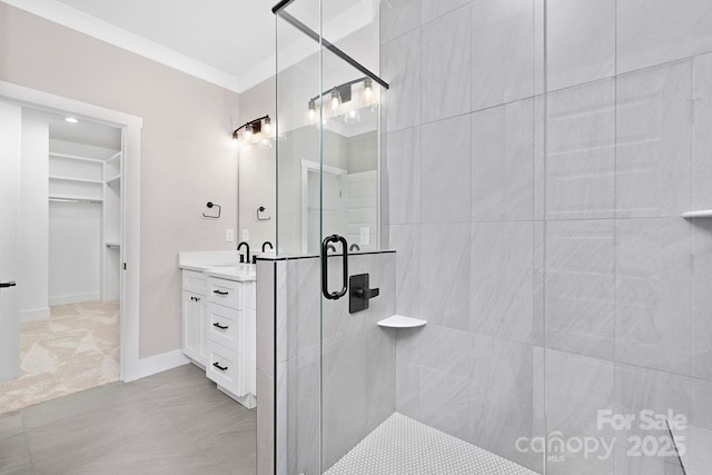 bathroom with ornamental molding, vanity, and a shower with shower door