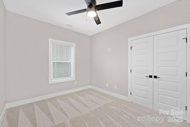 unfurnished bedroom with carpet floors, a closet, and ceiling fan