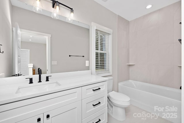 full bathroom with vanity, tiled shower / bath combo, and toilet