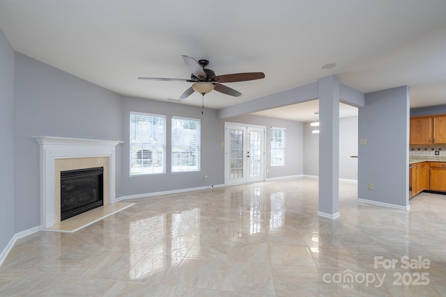 unfurnished living room featuring french doors and ceiling fan