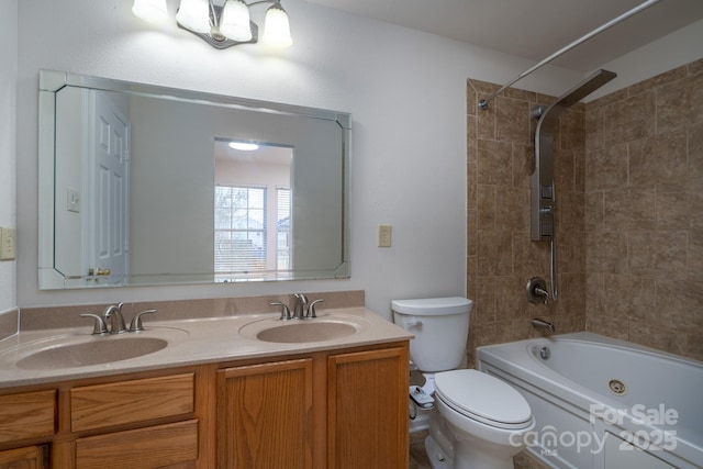 full bathroom featuring vanity, tiled shower / bath combo, and toilet