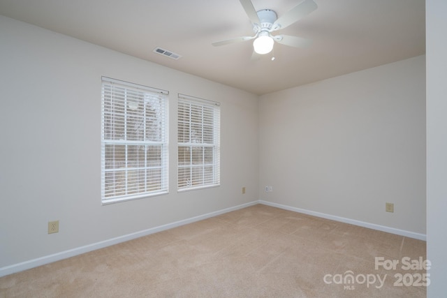 spare room featuring light carpet and ceiling fan