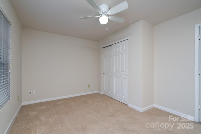 unfurnished bedroom featuring light carpet, a closet, and ceiling fan