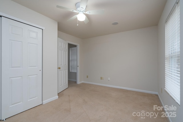 unfurnished bedroom with ceiling fan and light carpet