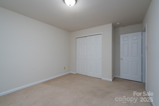 unfurnished bedroom with light carpet and a closet