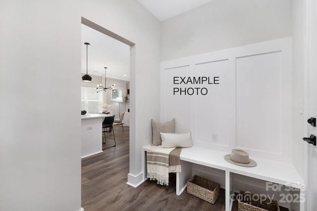 mudroom featuring dark wood-type flooring and a chandelier