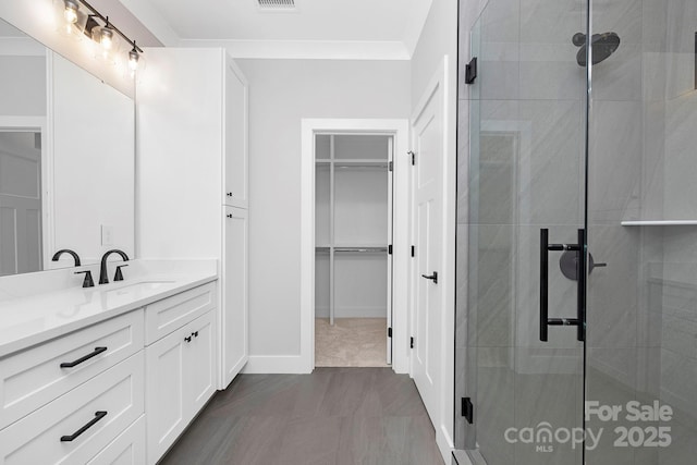 bathroom with vanity, walk in shower, and ornamental molding