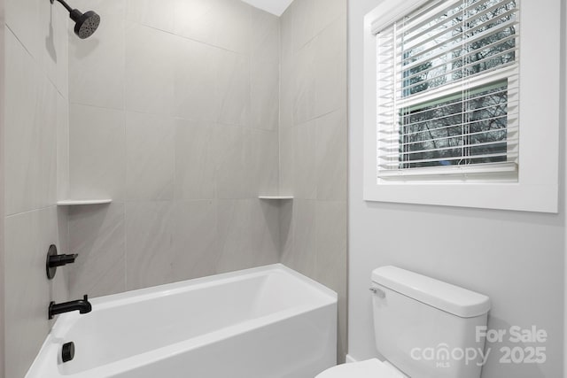 bathroom with toilet and tiled shower / bath