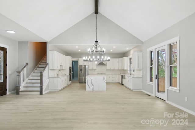 kitchen featuring white cabinets, light hardwood / wood-style flooring, sink, a kitchen island, and appliances with stainless steel finishes